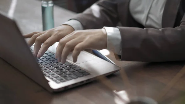 Mãos de empresária digitando em um teclado de computador. Mulher no local de trabalho com spray anti-séptico e paus de incenso nele — Fotografia de Stock
