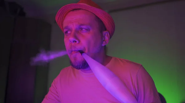 Przemyślany hipster wydycha dymy podczas czytania wiadomości w mediach w Internecie. Hookah Smoker w różowym fluorescencyjnym neonie świecącym. Samoizolacja podczas pandemii. Koncepcja kwarantanny — Zdjęcie stockowe