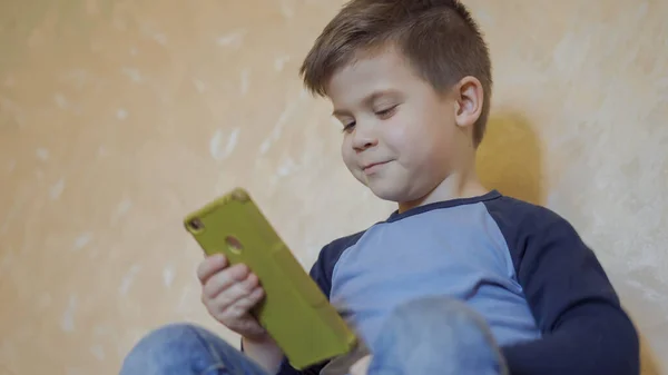 Los niños en edad preescolar usan un teléfono móvil para chatear con amigos en línea. Concepto de cuarentena. Concepto de tecnología inalámbrica de Internet — Foto de Stock