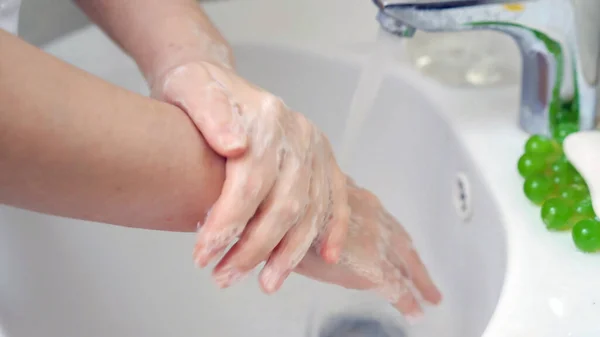 Γυναικεία χέρια σε σαπούνι. Η γυναίκα πλένει τα χέρια με αντιμικροβιακό σαπούνι. Υγεία και υγιεινή έννοια. Θολή κίνηση, κοντινό πλάνο. — Φωτογραφία Αρχείου
