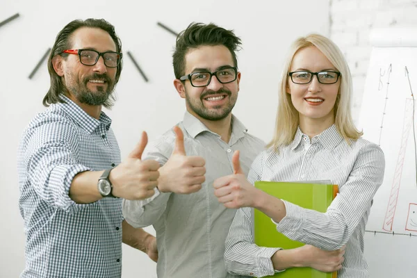 Equipe de negócios sorridente mostrando os polegares para cima gestos. Homens e mulheres mostram sinais de sucesso juntos no cargo. Imagem tonificada — Fotografia de Stock