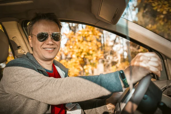 Angry asian woman showing middle finger or fuck leaning out the car window.  Mature asian woman