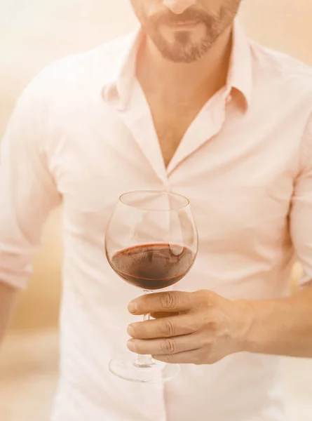 Bärtiger Mann hält ein Glas Rotwein in der Hand — Stockfoto