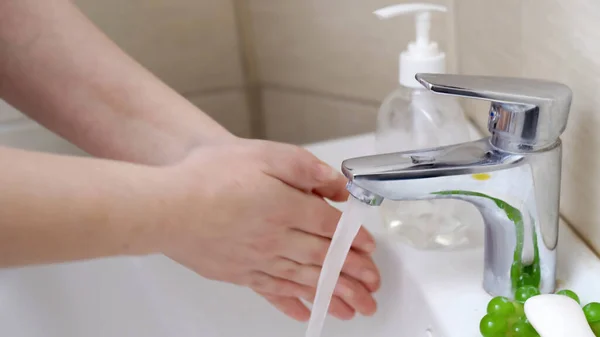 Η γυναίκα πλένει τα χέρια της. Κοντινό πλάνο. Γυναίκα είναι έτοιμος να πλύνει σαπουνόχερα της κάτω από ρεύμα ζεστού νερού πάνω από λευκό κεραμικό νιπτήρα στο μπάνιο. Έννοια υγιεινής και υγείας — Φωτογραφία Αρχείου