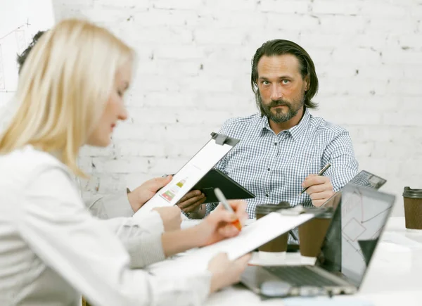 Empresasvapor brainstorming no escritório. Os trabalhadores criativos estão envolvidos em trabalho em papel enquanto trabalham em um novo projeto enquanto se sentam juntos em uma mesa. Imagem tonificada — Fotografia de Stock