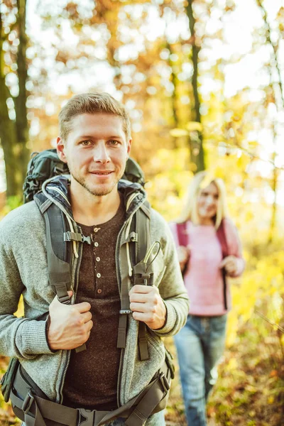 Twee backpackers toeristen in de herfst natuur, vrolijk stel, Kaukasische man en vrouw op weg naar nieuwe avonturen, reis in de natuur. Wandelconcept — Stockfoto