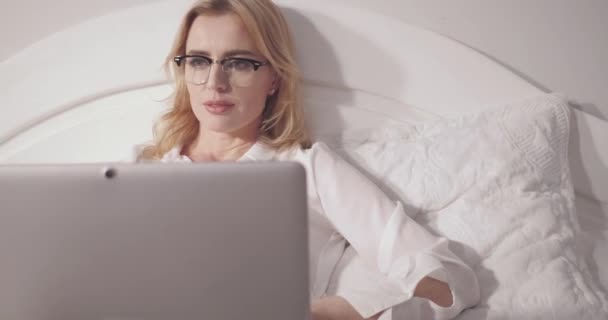 Obchodní žena pracující na laptopu, zatímco leží v posteli. Podnikatelka pracuje dlouho do noci na přípravě dokumentů nebo revizi projevu na sympoziu. Prores 422 — Stock video