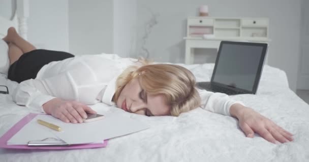 Tired business woman fell asleep working on a laptop in bed. Businesswoman works late preparing documents or revising speech for speech at a symposium. Prores 422 — Stock Video