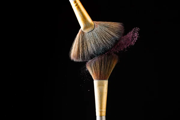 Make-up brushes with pink powder isolated on black background — Stock Photo, Image