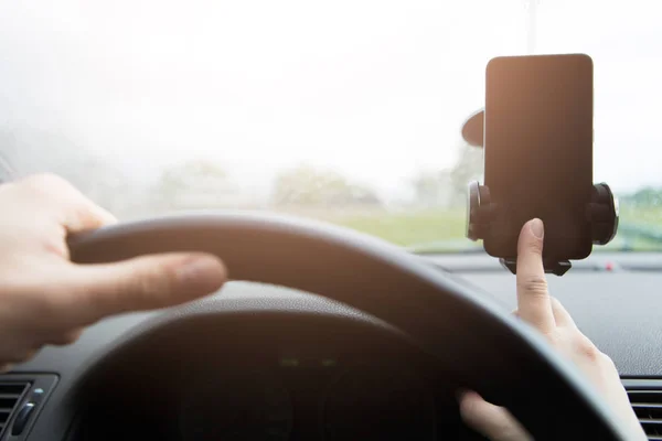 Man behind wheel with smartphone — Stock Photo, Image