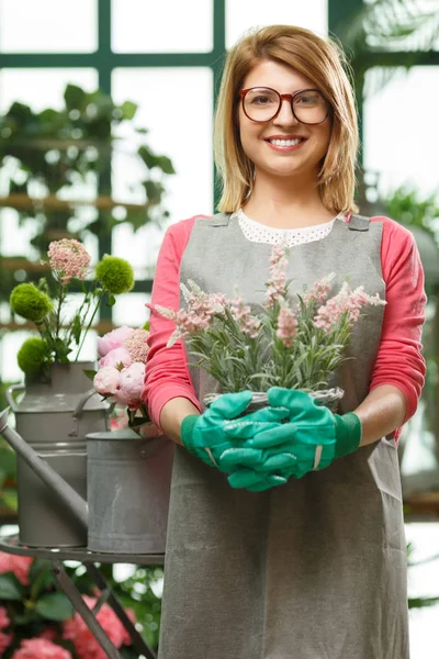 Fiorista con fiori in negozio — Foto Stock