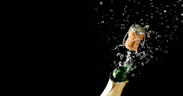 Abrindo garrafa de champanhe no fundo preto vazio — Fotografia de Stock