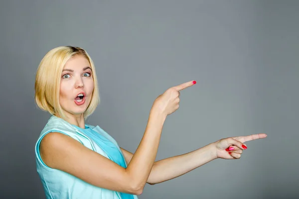 Beautiful girl points with fingers — Stock Photo, Image