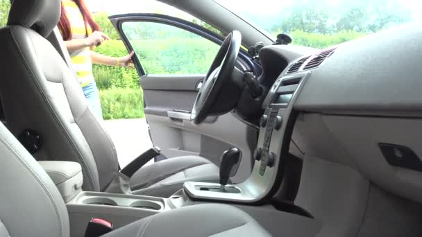 Młoda kobieta siedzi w samochód, Uruchom silnik i dojazd — Wideo stockowe