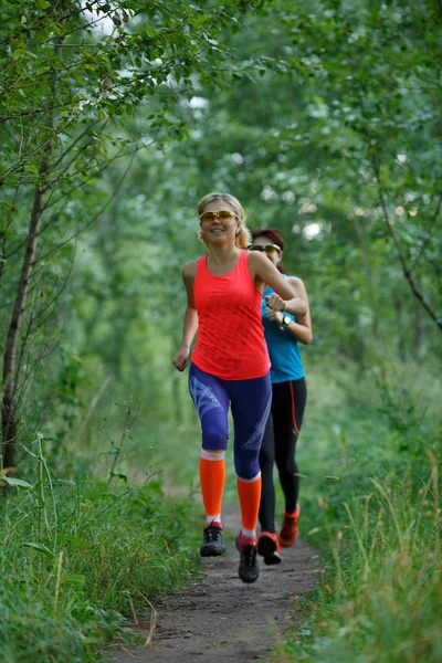 Atletas do sexo feminino treinando na floresta — Fotografia de Stock