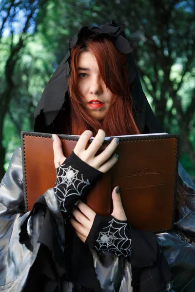 Retrato de bruja en capa con libro —  Fotos de Stock