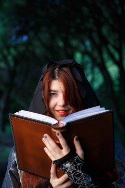 Cadı kitap ile pelerin içinde resmi