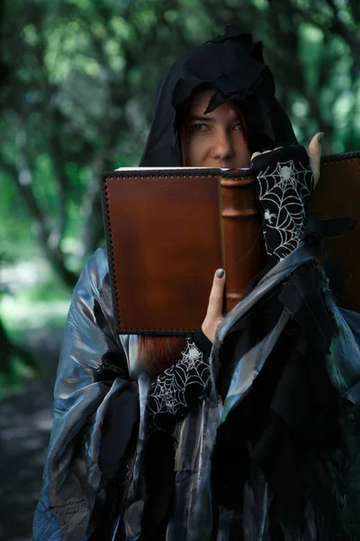Imagen de bruja negra con libro de magia — Foto de Stock