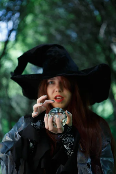 Witch in zwarte hoed met magische bal — Stockfoto