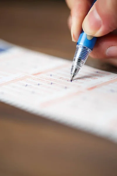 Photo of person marking in lottery ticket — Stock Photo, Image