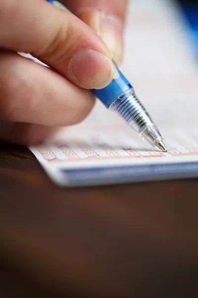 Foto van persoon schrijven in loterijbriefje — Stockfoto