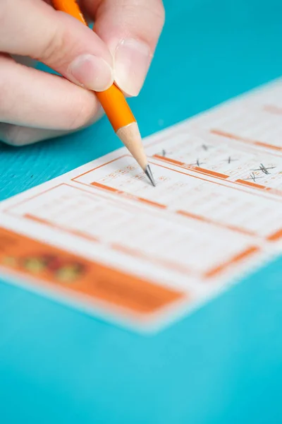 Крупным планом изображение рук человека с карандашом, лотерейный билет — стоковое фото