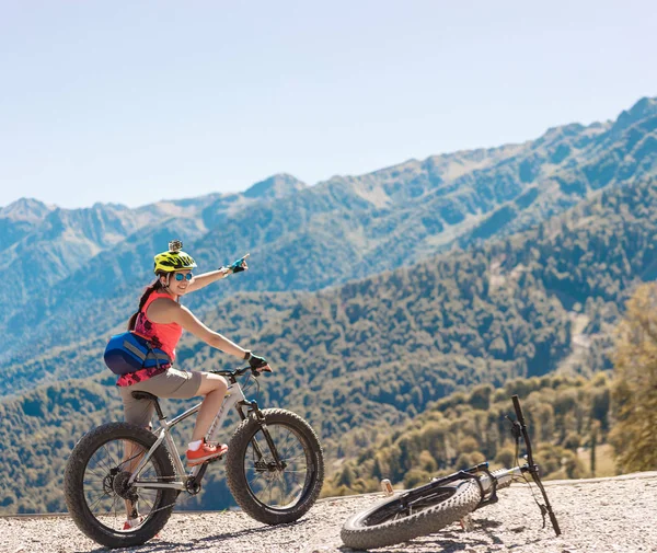 Photo of woman in helmet on bicycle showing hand — Stock Photo, Image