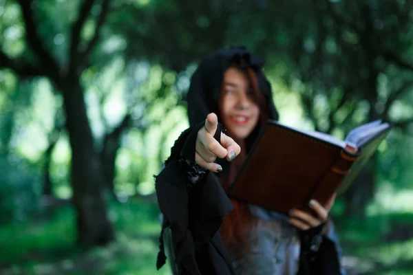 Изображение улыбающейся ведьмы с книгой — стоковое фото