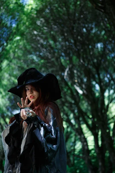 Foto de una bruja joven en un bosque sombrío — Foto de Stock