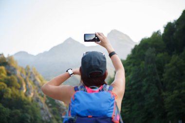 Kız sırt çantası ile smartphone ile arka üzerinden fotoğraf
