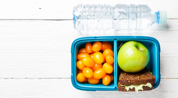 Foto van cherry tomaat, appel, sandwich in lunchbox, fles — Stockfoto