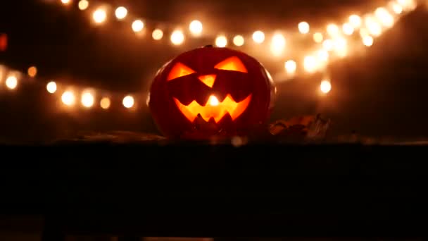 Citrouille d'Halloween sculptée avec des lumières sur le fond. Images clés sombres en résolution UltraHd. Vidéo 4k 