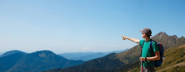 Foto do turista apontando para longe das montanhas cênicas — Fotografia de Stock