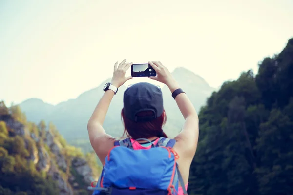 Imagen de la parte posterior de la chica turística con mochila con smartphone —  Fotos de Stock