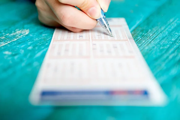 Imagem de mão de homem com caneta e bilhete de loteria — Fotografia de Stock