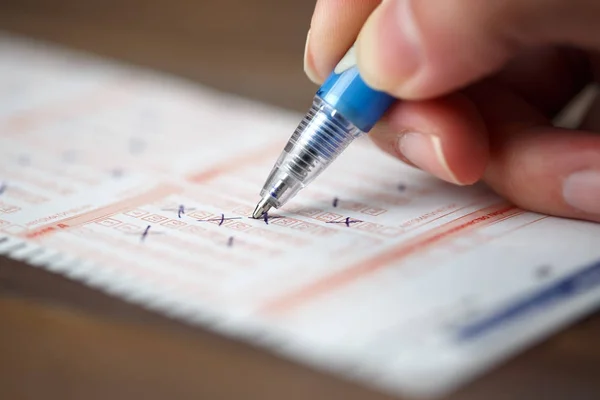 Image of person marking in lottery ticket — Stock Photo, Image