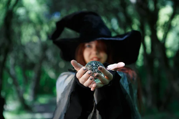 Bruxa segurando bola mágica nas palmas das mãos — Fotografia de Stock