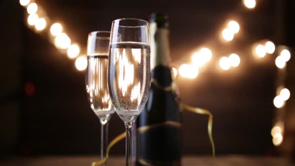 Two Flutes with Sparkling Wine over Holiday Bokeh Blinking Background. ultra hd footage. — Stock Video