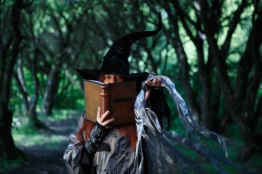 Cadı görüntü sihirli kitap büyü ve karanlık ormanın karşı uzanmış el ile