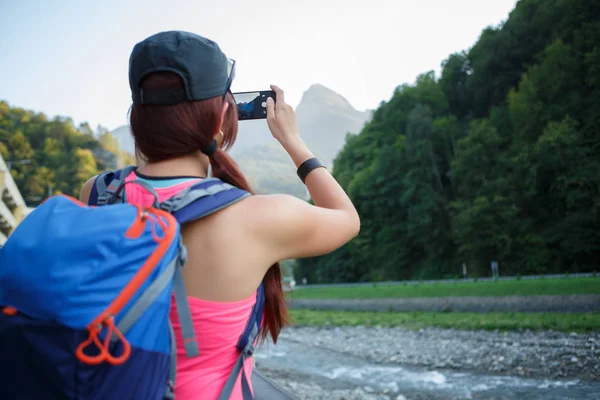 Foto von der Rückseite der brünetten Touristin fotografiert Berg — Stockfoto