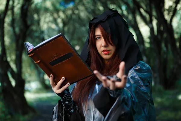 Bruja con libro de hechizos en la capucha — Foto de Stock