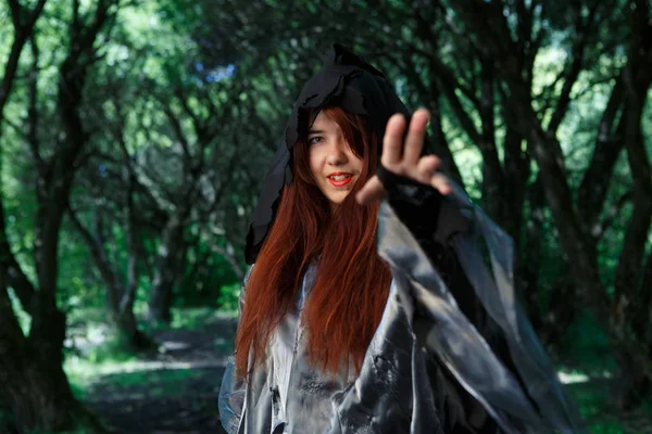 Čarodějnice v plášti v lese — Stock fotografie