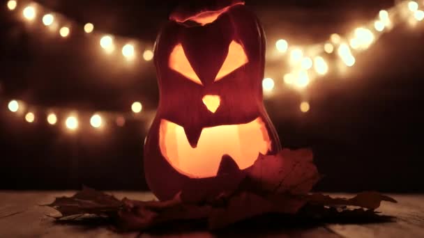 Zucca di Halloween intagliata con luci sullo sfondo. Filmati chiave scuri nella risoluzione UltraHd . — Video Stock