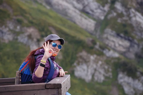 Imagem da menina em cap mostrando ok de pé na ponte — Fotografia de Stock