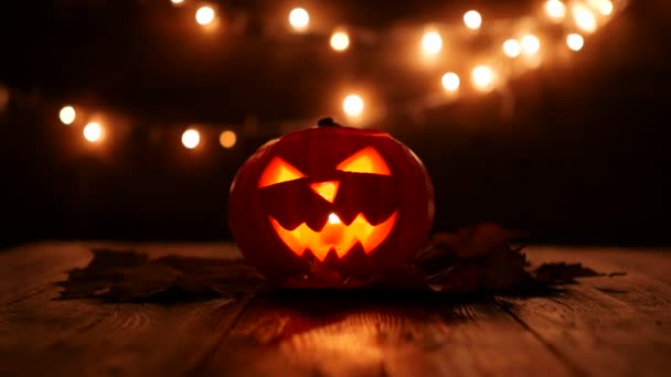 Zucca di Halloween intagliata con luci sullo sfondo. Filmati chiave scuri nella risoluzione UltraHd . — Video Stock