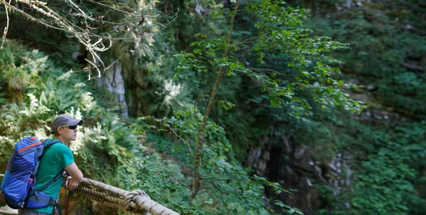 Image of man with backpack on rock background — Stock Photo, Image