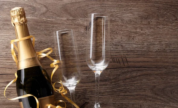 Φωτογραφία δύο wineglasses, μπουκάλι σαμπάνιας, χρυσό κορδέλες — Φωτογραφία Αρχείου