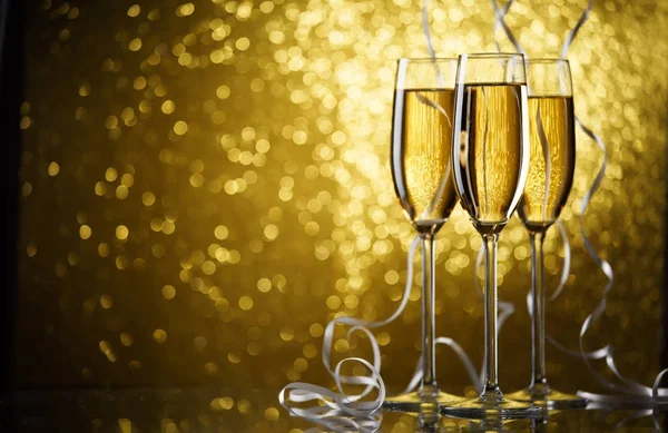 Bild von drei Gläsern mit Champagner auf goldenem Hintergrund. — Stockfoto