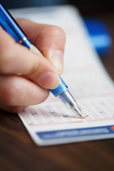 Image of person writing in lottery ticket — Stock Photo, Image
