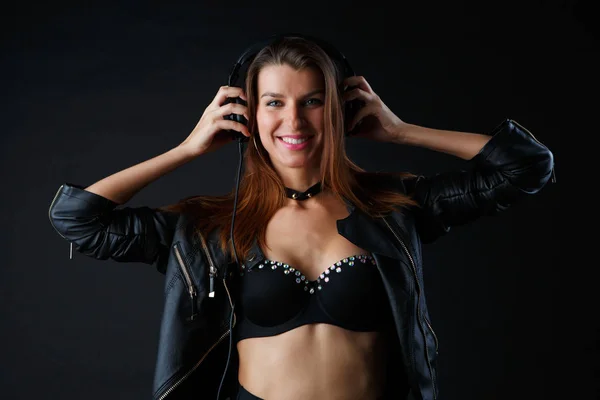 Image of young woman wearing headphones in leather jacket — Stock Photo, Image